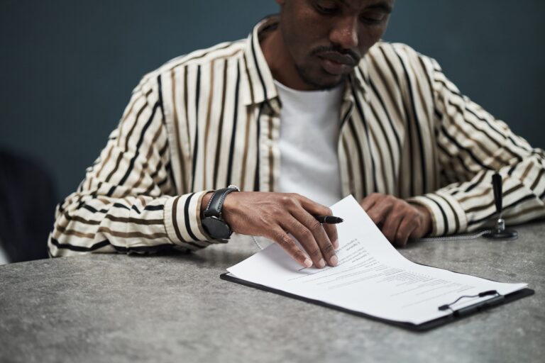 Young,Black,Man,Reviewing,And,Signing,Financial,Loan,Documents,At