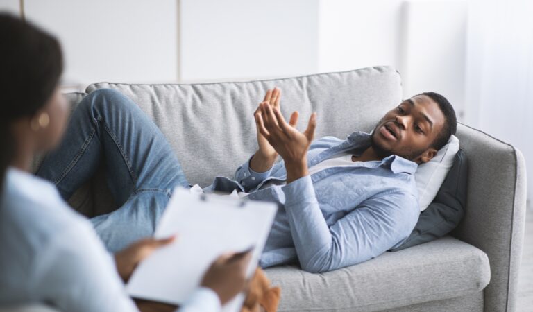 Unhappy,Young,Black,Guy,Lying,On,Couch,In,Psychologist's,Office,