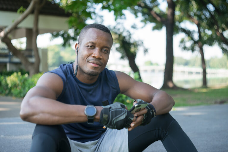 Muscular,Black,Man,Smiling,,Confident,And,Relaxed,,Chatting,On,Smartphone