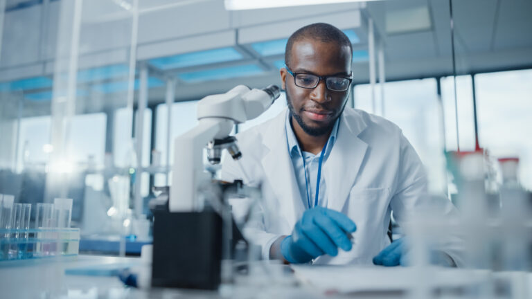 Modern,Medical,Research,Laboratory:,Portrait,Of,Male,Scientist,Using,Microscope,